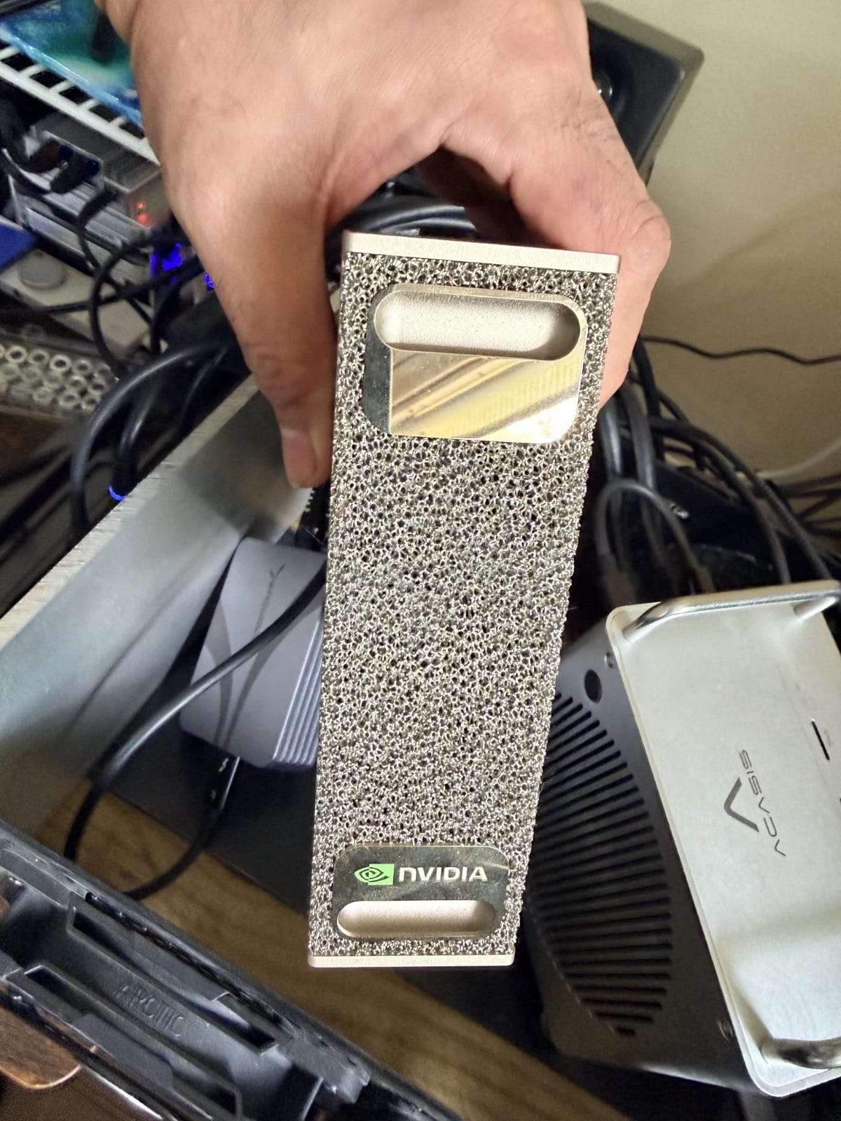 An owner holding the DGX Spark in a home lab